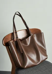 Detailed view of large brown leather tote bag with adjustable straps and spacious interior