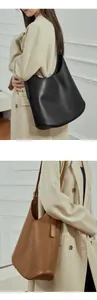 Close-up of minimalist crescent tote bags in black and brown high-quality smooth leather
