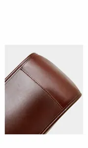 Détail des coutures robustes et du cuir marron de qualité sur le fond du sac à main