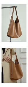 Detail of a dark brown leather hobo bag with adjustable strap shown on model in beige coat