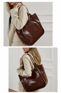 Présentation sur mannequin d'un grand sac cabas en cuir ciré marron foncé brillant