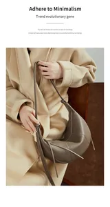 Detail of coffee brown pebble leather croissant bag with contrast stitching and tassels