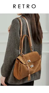 Brown suede leather tote bag worn over a grey herringbone coat with silver lock detail