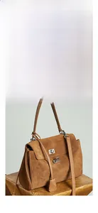 Detail view of brown matte leather tote bag with metal twist lock and adjustable strap