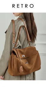 Detail of silver twist-lock on large brown frosted leather tote with adjustable strap