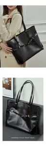 Detailed macro view of black leather tote bag featuring gold metal buckles and tie strap