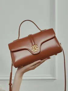Brown vintage leather handbag with gold geometric buckle and adjustable strap