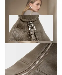 Macro detail of silver metal zipper and lychee grain leather texture on tote bag