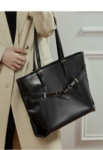 Detail of premium black leather tote showing soft texture and sleek metal buckle strap