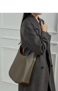 Close-up of olive gray leather hobo bag with detailed stitching on a female model