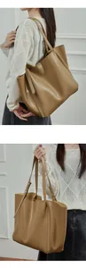 Detailed close-up showing soft khaki brown leather texture and stitching of tote bag