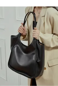 Gros plan d'un grand sac cabas en cuir noir à texture souple porté par un mannequin