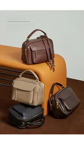 Collection de sacs à main en cuir en quatre couleurs sur un banc incurvé moderne