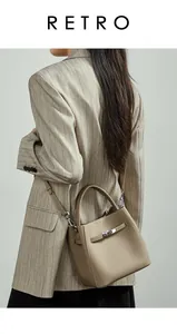 Détail de la texture cuir de lychee gris et fermoir métallique du sac seau