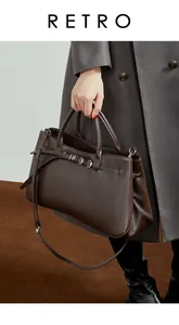 Vue détaillée du sac baguette en cuir marron foncé avec boucle double argentée