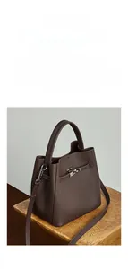 Détail du mini sac seau en cuir marron foncé avec fermoir métallique et bandoulière