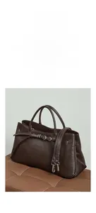 Détail du sac baguette en cuir marron avec boucle décorative et finitions métalliques