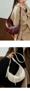 Detail of hobo bag with pebbled leather texture and decorative tassel on the strap