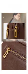 Détail d'un sac à main en cuir marron foncé avec ferrures dorées et zip métallique gravé