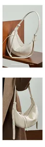 Detail of cream leather croissant bag showing soft texture and adjustable strap