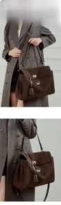 Detailed view of a brown suede leather tote with a silver buckle closure on a model
