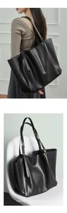 Detail view of large matte black tote bag with adjustable strap and silver metal buckle