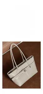 Detail shot of the textured grey leather tote bag with elegant metal buckle and strap