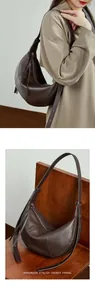 Detail of dark brown pebble leather croissant bag with fine stitching and zip closure