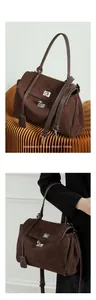Detail of dark brown suede tote bag featuring silver turn-lock and vintage strap design