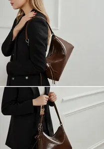 Detalle de bolso de hombro en cuero encerado marrón oscuro con geometría triangular y correas