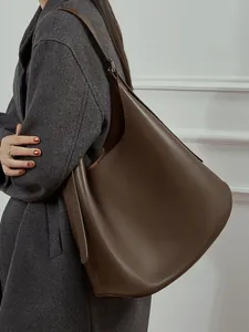 Minimalist deep brown matte leather hobo bag with adjustable wide strap on model