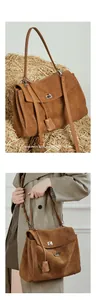 Detailed macro view of the brown suede handbag with a silver twist lock and strap