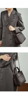 Détail du sac seau en cuir grainé marron foncé avec fermoir rotatif en métal argenté
