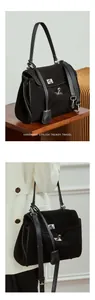 Macro detail of a black matte leather tote with vintage silver twist lock and strap