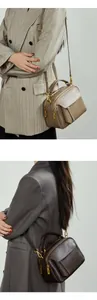 Détail de sac bandoulière en cuir avec ferrures dorées et plusieurs compartiments