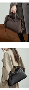 Détail du sac baguette en cuir minimaliste avec boucle en métal en noir et marron