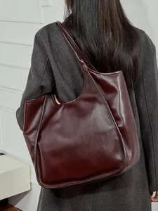 Grand sac cabas en cuir marron rouge foncé avec large bandoulière pour un style minimaliste