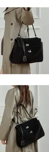 Macro view of large black matte leather tote bag featuring elegant silver square buckles