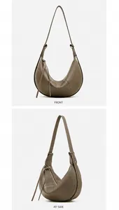 Detail view of grey litchi leather crescent bag featuring contrast stitching and zipper