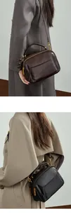 Détail de la ferrure dorée mate et de la fermeture éclair double sur le sac en cuir