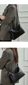 Detalle de bolso de hombro en cuero negro brillante con correa ajustable de moda