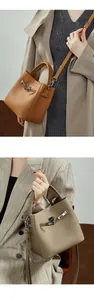 Détail macro du sac seau en cuir grainé avec boucle en métal et bandoulière amovible