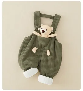 Dettaglio salopette neonato verde muschio in maglia a nido d'ape con orsetto di peluche