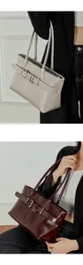 Detailed close-up of leather tote bags in off-white and burgundy with stylish belt buckle
