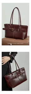 Close-up of wine red leather tote bag showing glossy texture and gold buckle detail