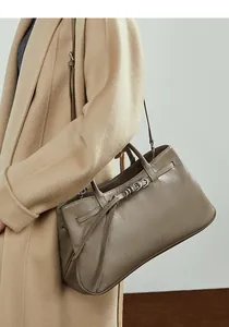 Détail du sac baguette en cuir de vachette avec boucle de ceinture et crochets argentés