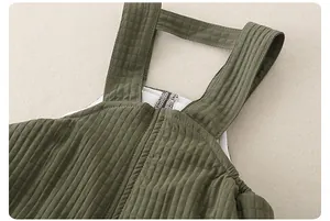Dettaglio della salopette trapuntata verde militare per neonato con zip e fodera