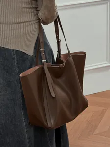 Large dark brown leather tote bag with adjustable shoulder straps for minimalist commute