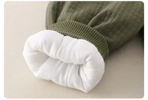 Dettaglio in tessuto trapuntato verde militare con polsino a coste e fodera in pile bianco