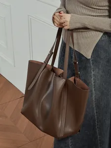 Brown large capacity leather tote bag for women showing a stylish side view and strap detail